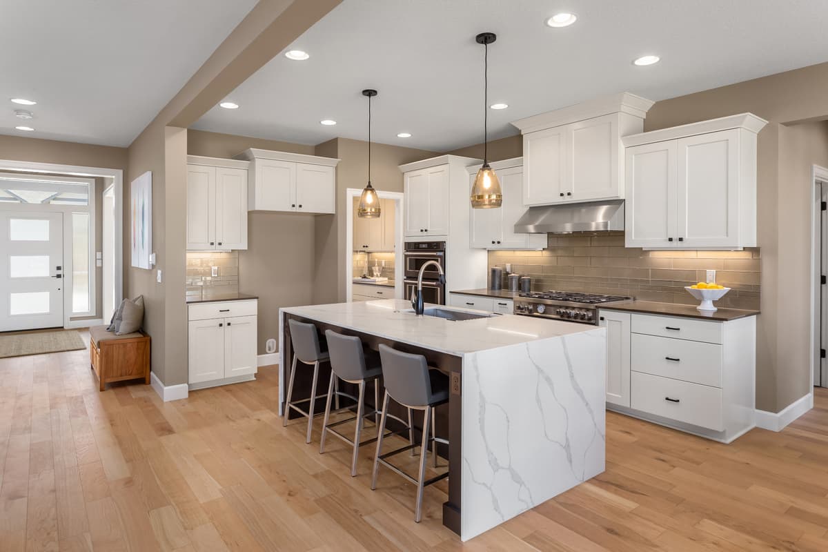 Modern kitchen with white cabinets and marble waterfall island